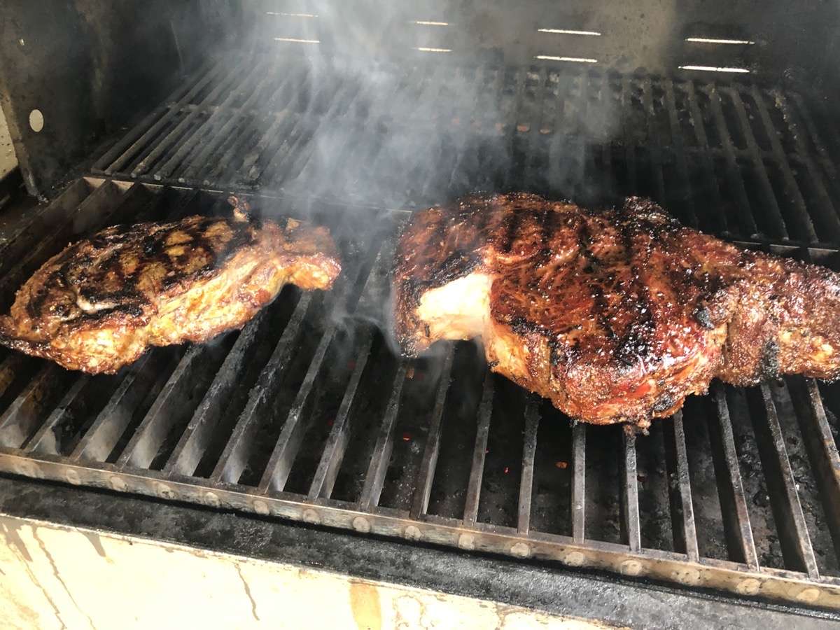 3lb bone-in ribeye on right cooking with boneless ribeye on left. Both steaks are being cooked on the Mak Grills Searing Grates which get blazing hot.