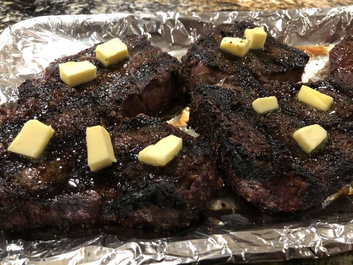 Steaks resting with butter on top. We placed another piece of foil on top and let them rest for 10 minutes.