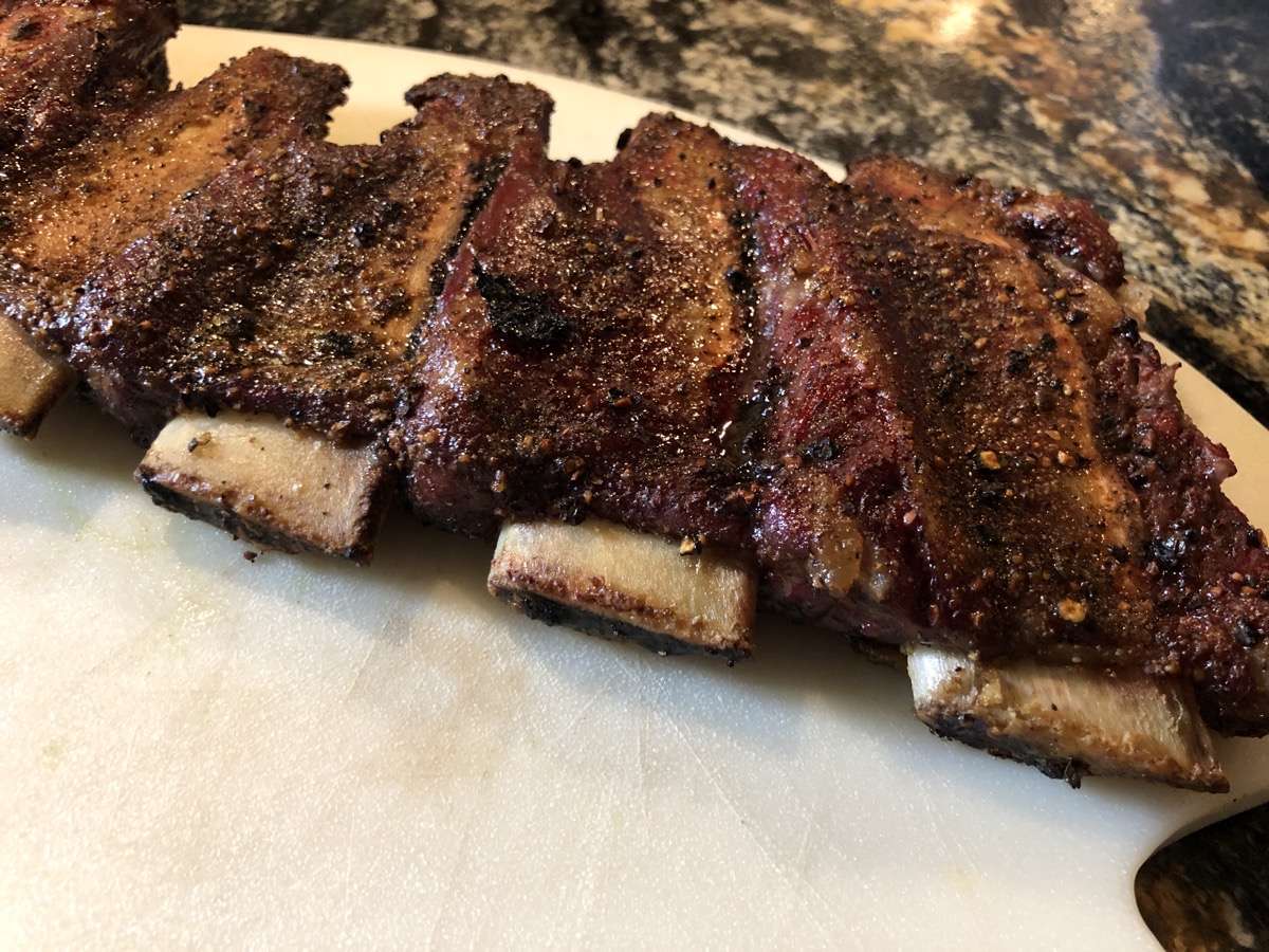 Meat pulled up on the bone on beef finger ribs