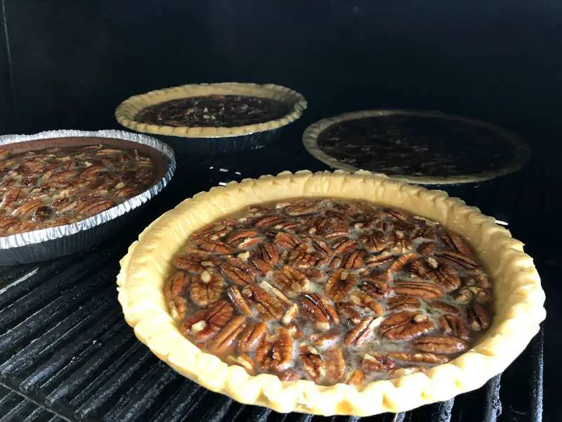 Four pecan pies cooking on the MAK 2 Star pellet grill upper rack. 