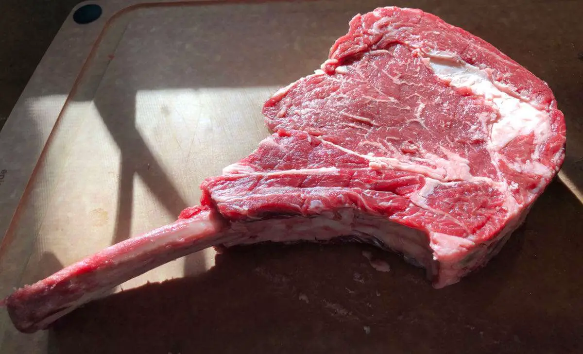 Beautiful tomahawk ribeye steak ready for seasoning.