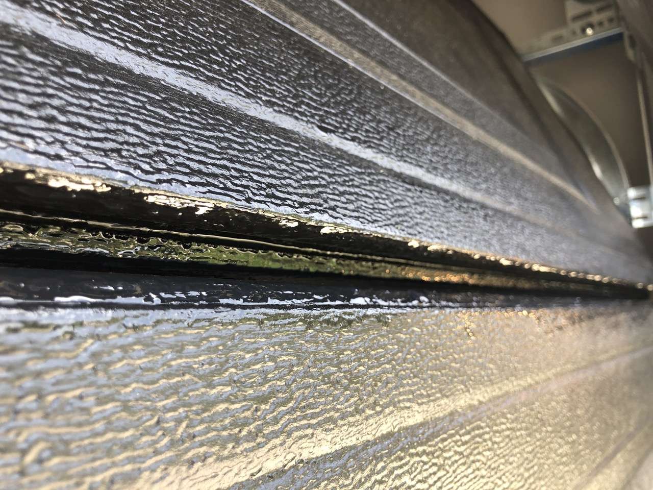 Black paint applied in between the garage door sections is causing the door to make popping noises when opening.