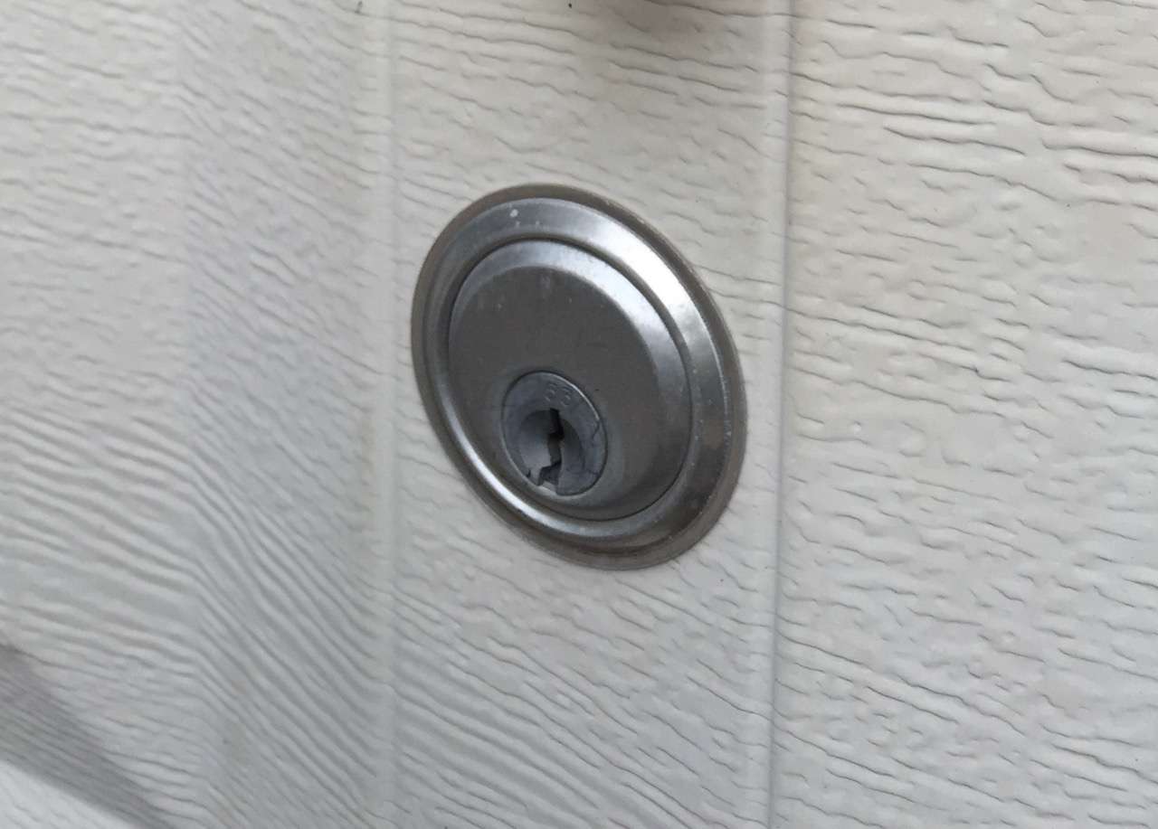 Outside keyed lock cylinder on a garage door.