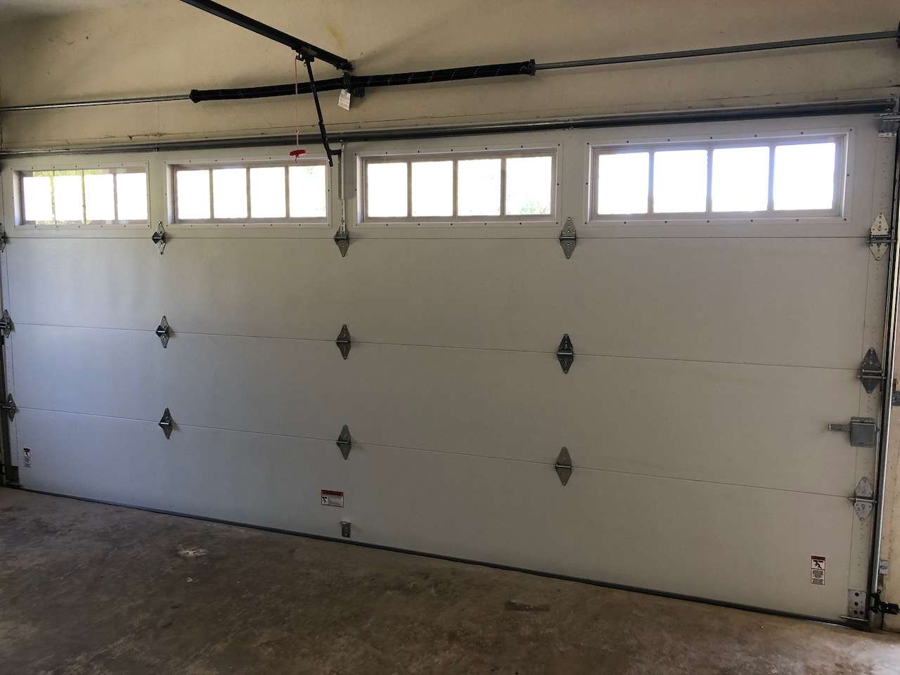 Steel back garage door with full insulated windows in the top section.