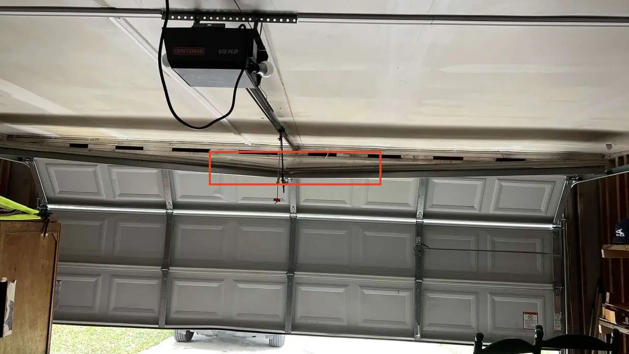 Top section bent on double car width garage door.