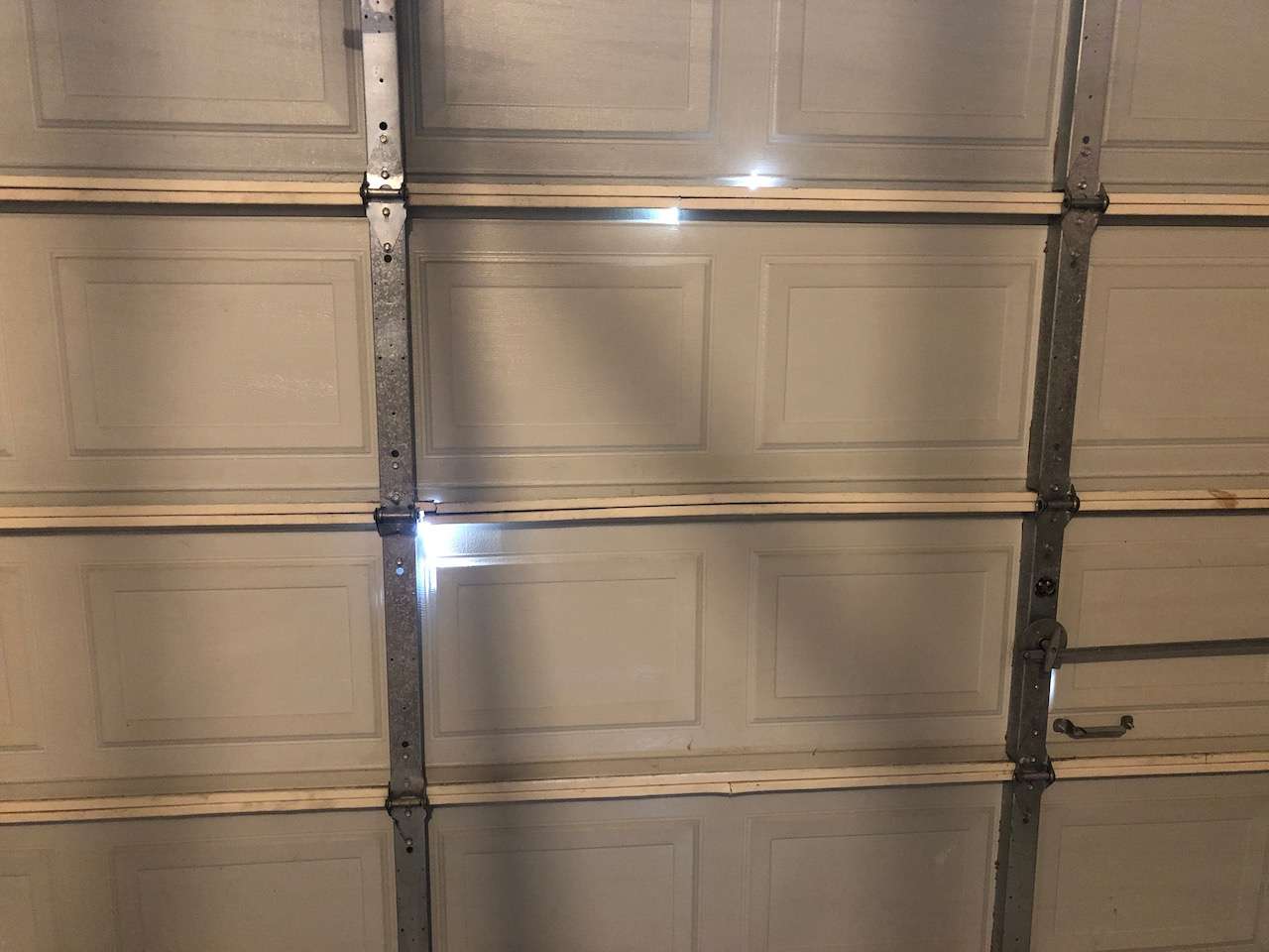 This aging garage door is starting to generate cracks in all the sections. At that point it might be time for replacement.