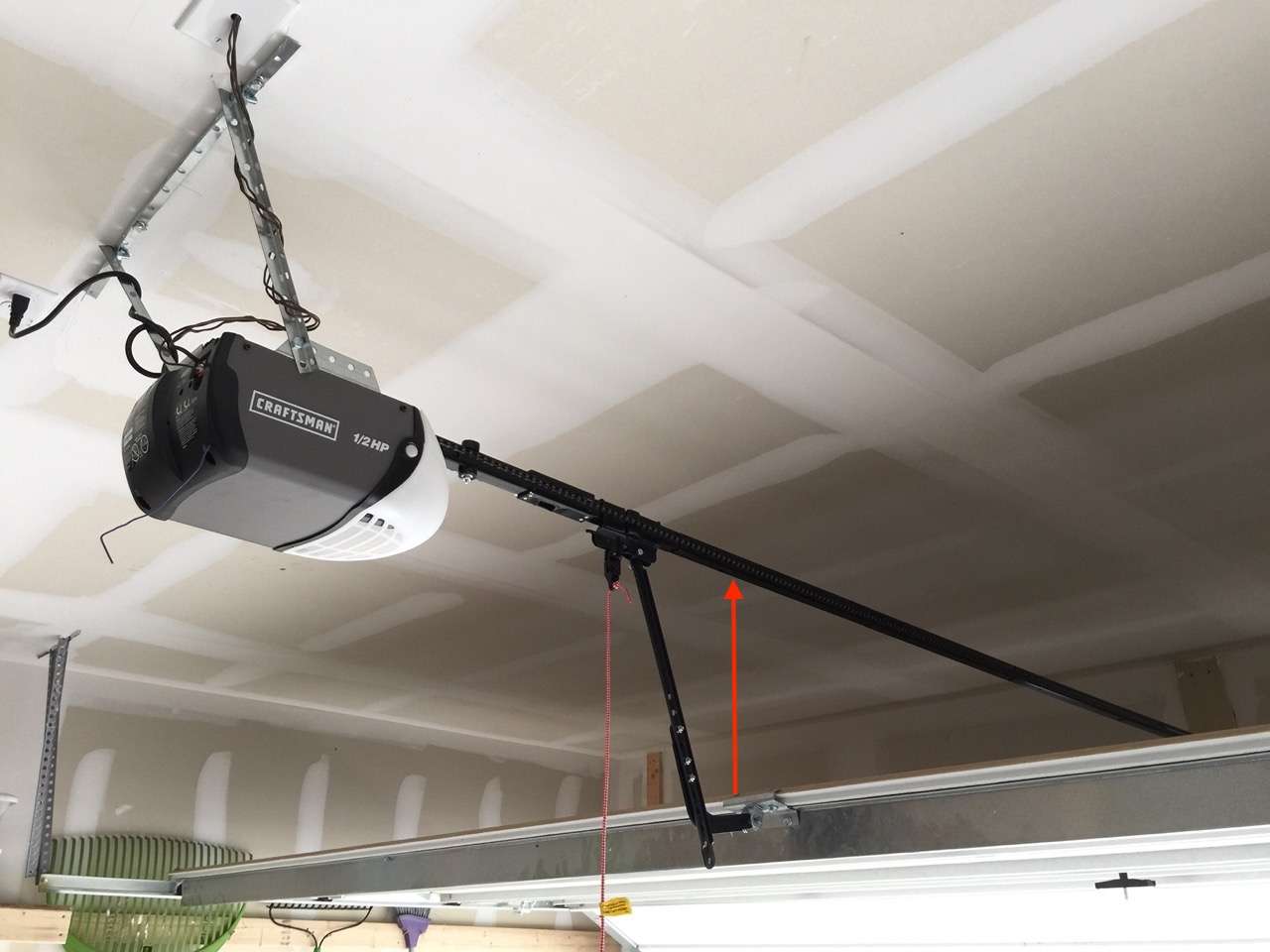 The garage door opener is mounted too high above the garage door which puts the pickup arm at the wrong angle. The rail should be no more than a couple of inches above the door.