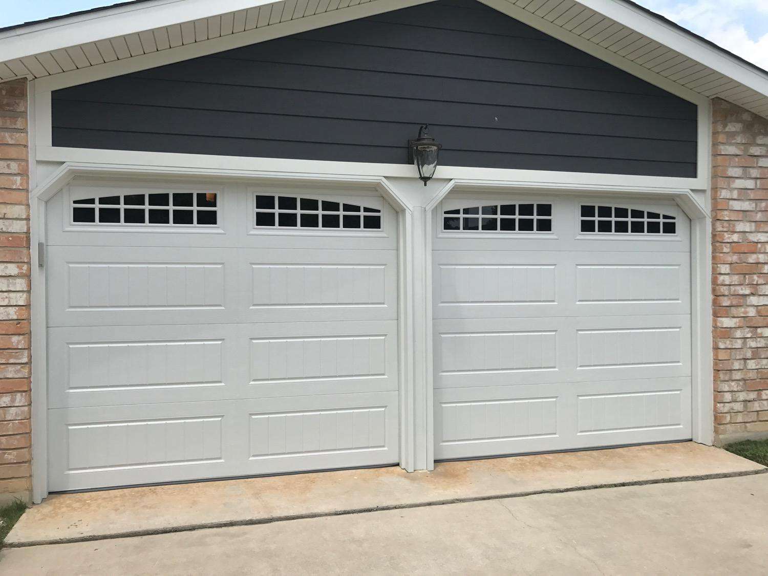 Long stamped carriage garage doors with moonlight windows.