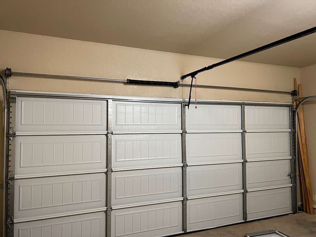 A quality non-insulated 16x7 garage door with three vertical rows of stiles.