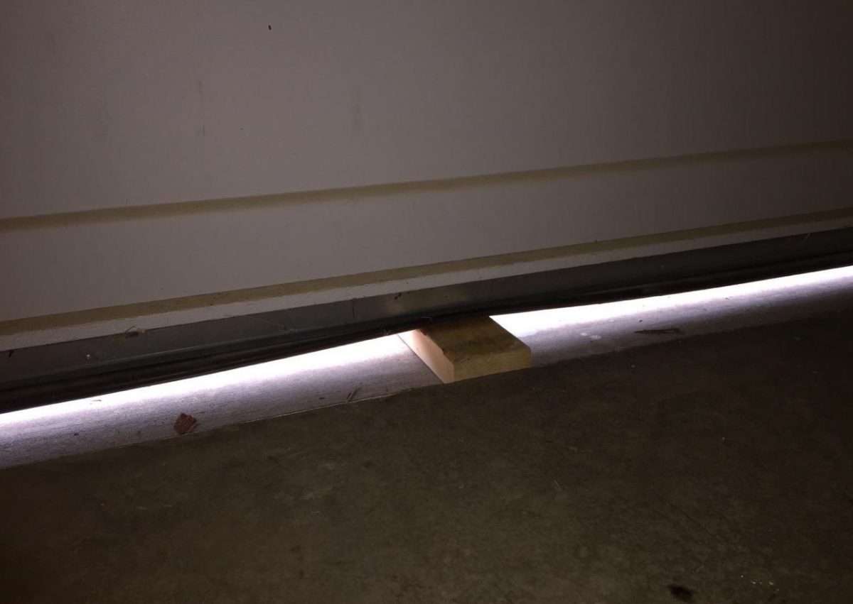 2x4 board laying flat under garage door section.