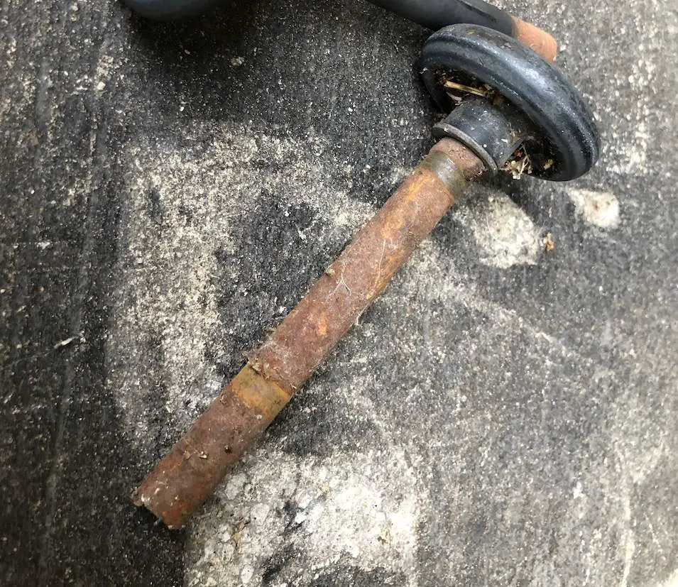 Garage door roller with plastic tire and rusted stem.