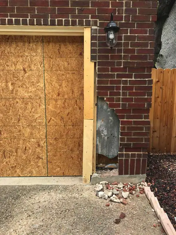 Vehicle ran into garage door opening damaging the brick veneer and framing structure.