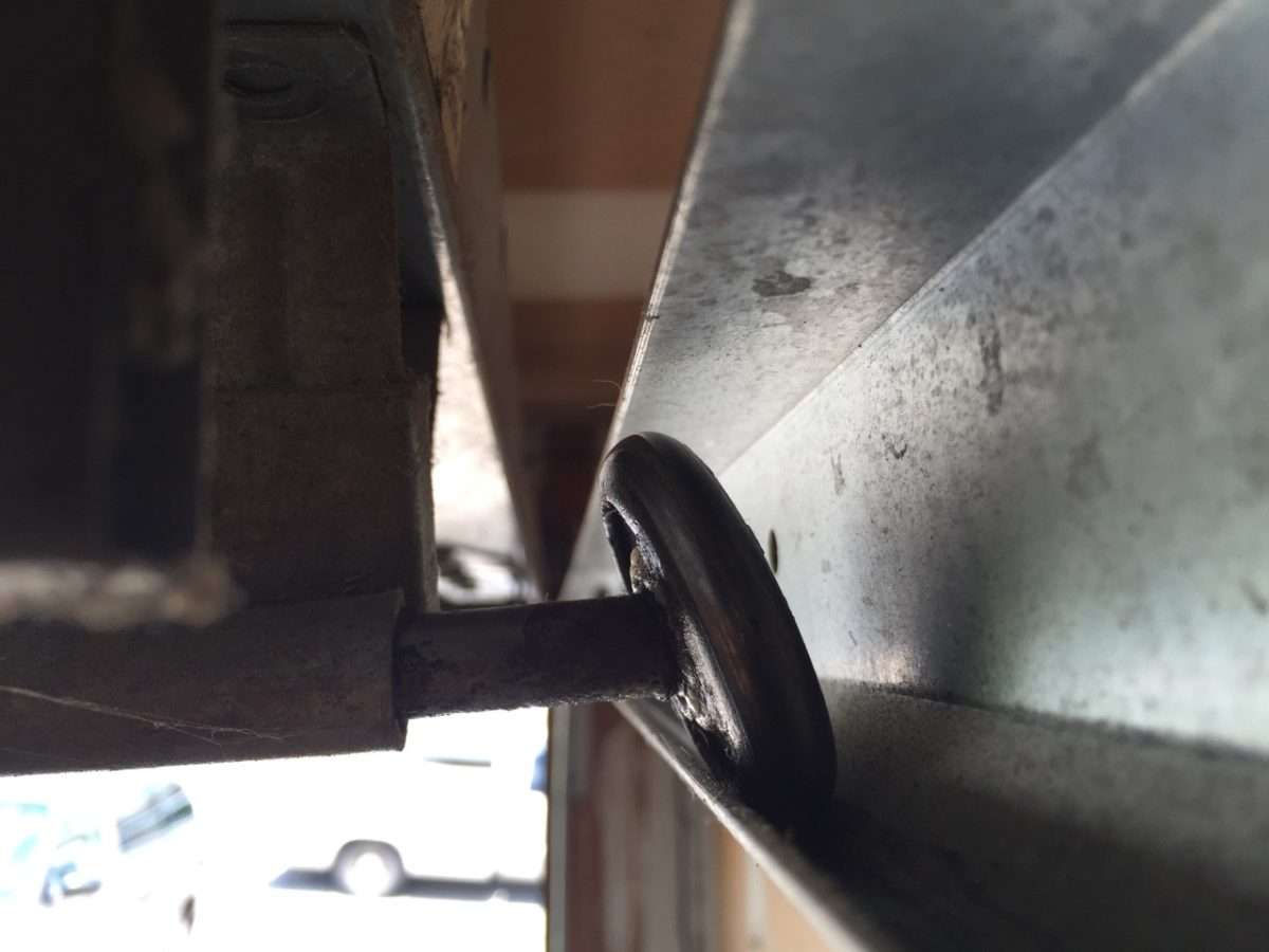 Leaning garage door metal roller due to bearing failure.