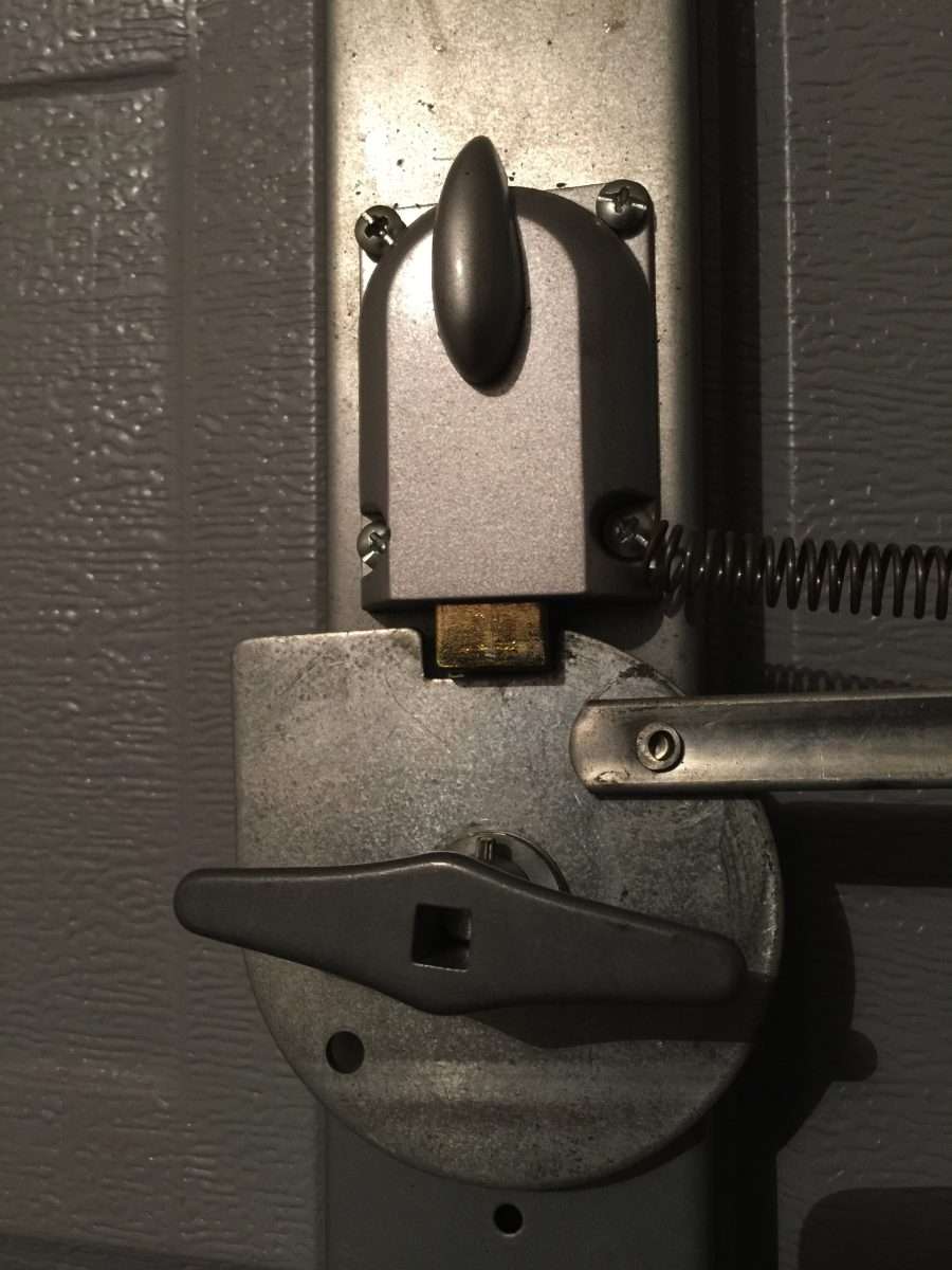 Interior night latch installed on a garage door with an outside keyed lock.