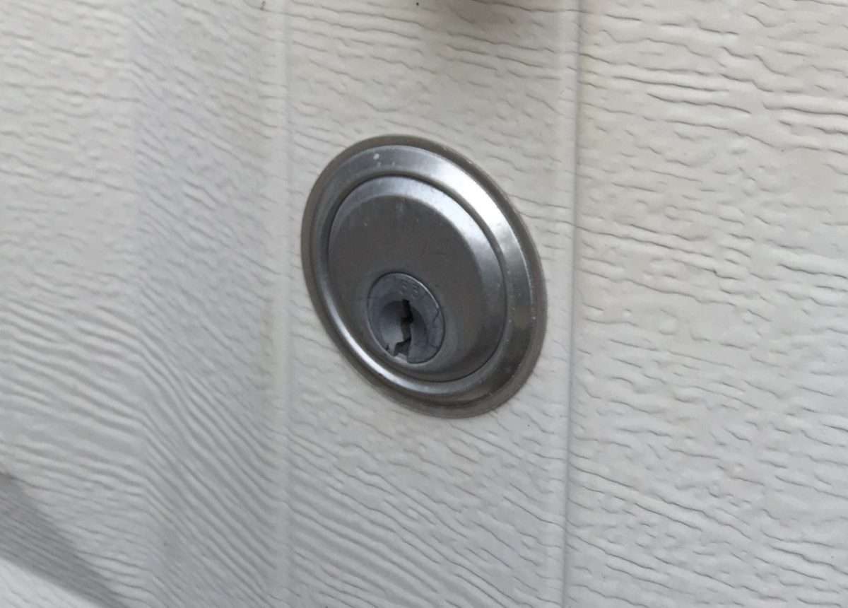 Keyed lock cylinder on the outside of a garage door section.