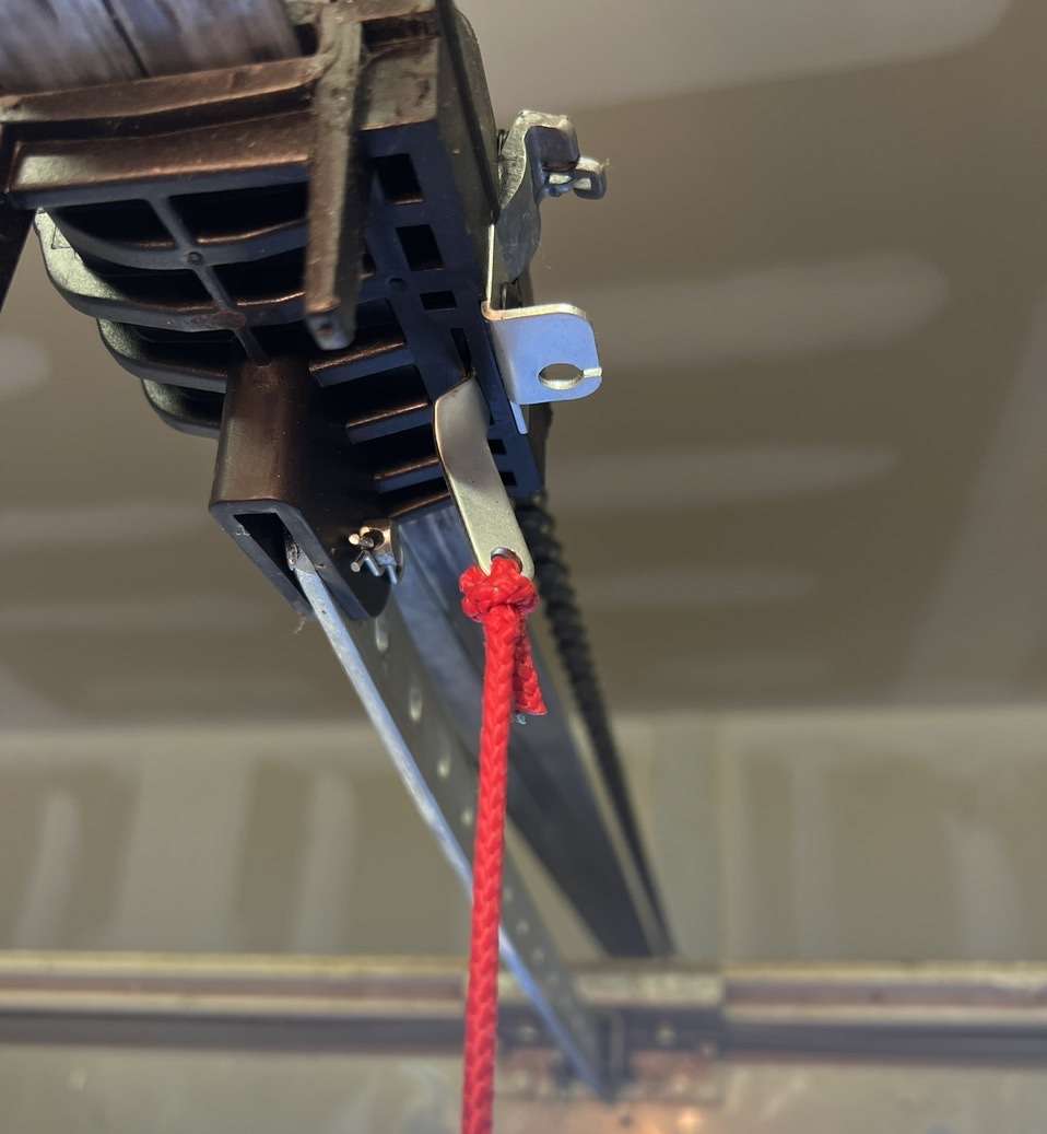 Bent metal tab on Genie 1024 opener trolley is preventing the trolley from disconnecting from the inner slide.