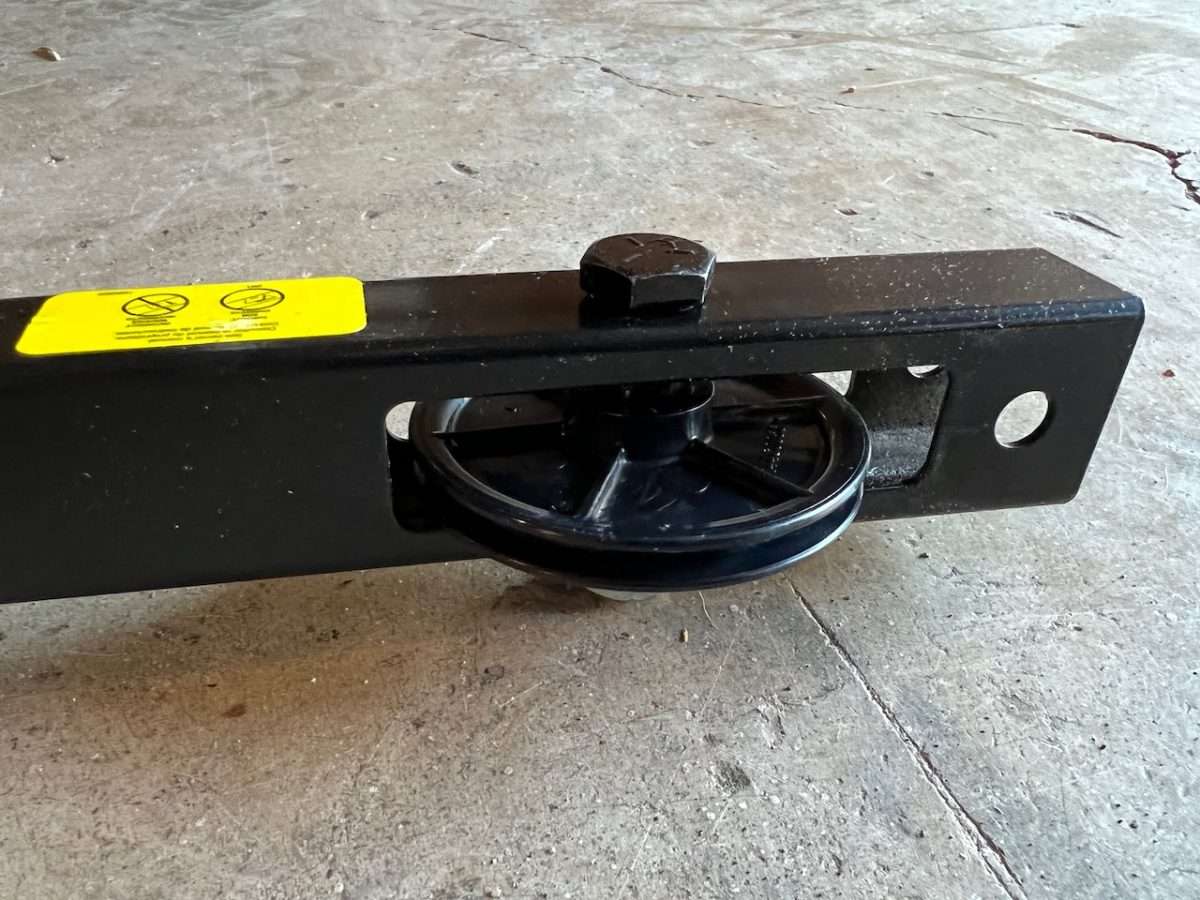 Front cable pulley on Chamberlain chain drive garage door opener.
