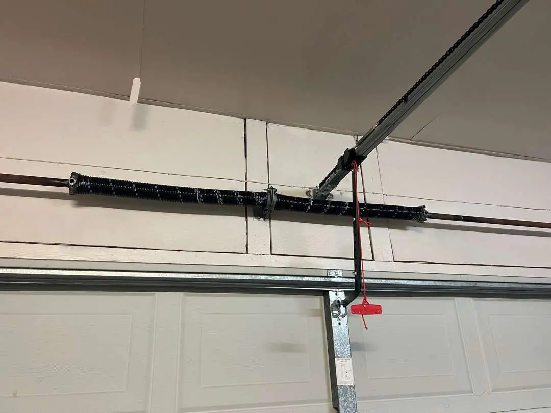 New pair of torsion springs above a garage door. These springs are what lifts the full weight of your garage door.