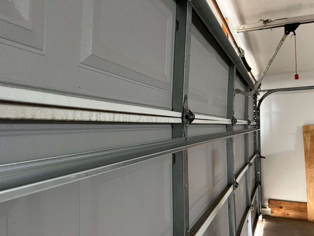 Reinforcement strut installed on third section of garage door.