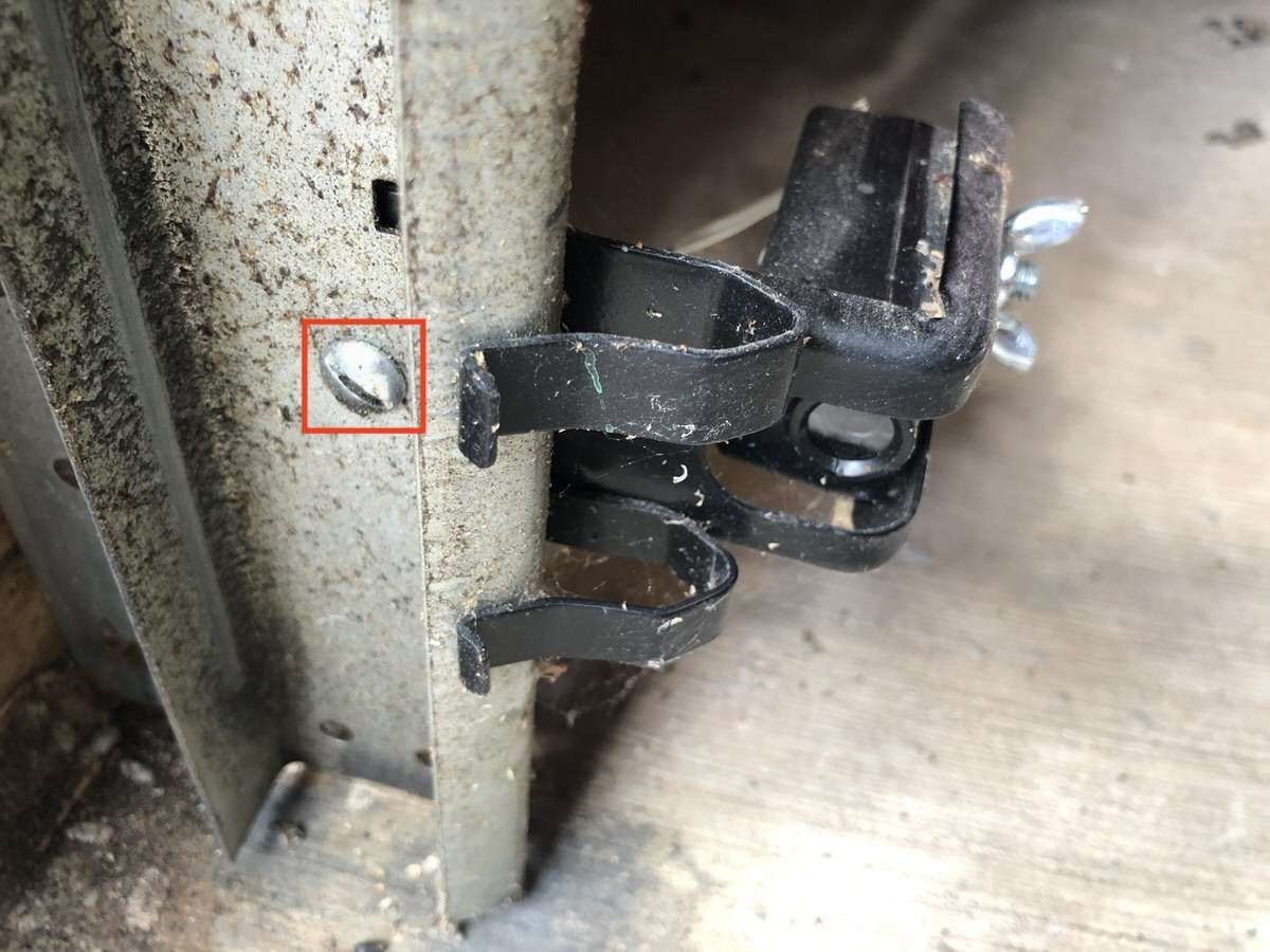 LiftMaster safety sensor brackets bolted to the garage door vertical tracks with a track bolt.