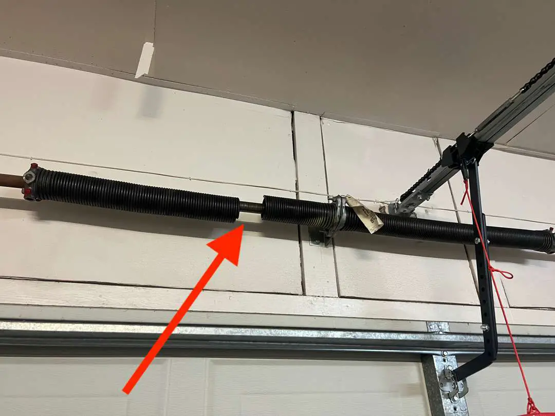 Pair of torsion springs above the garage door. The left spring is broken with a 2 inch gap in the spring.